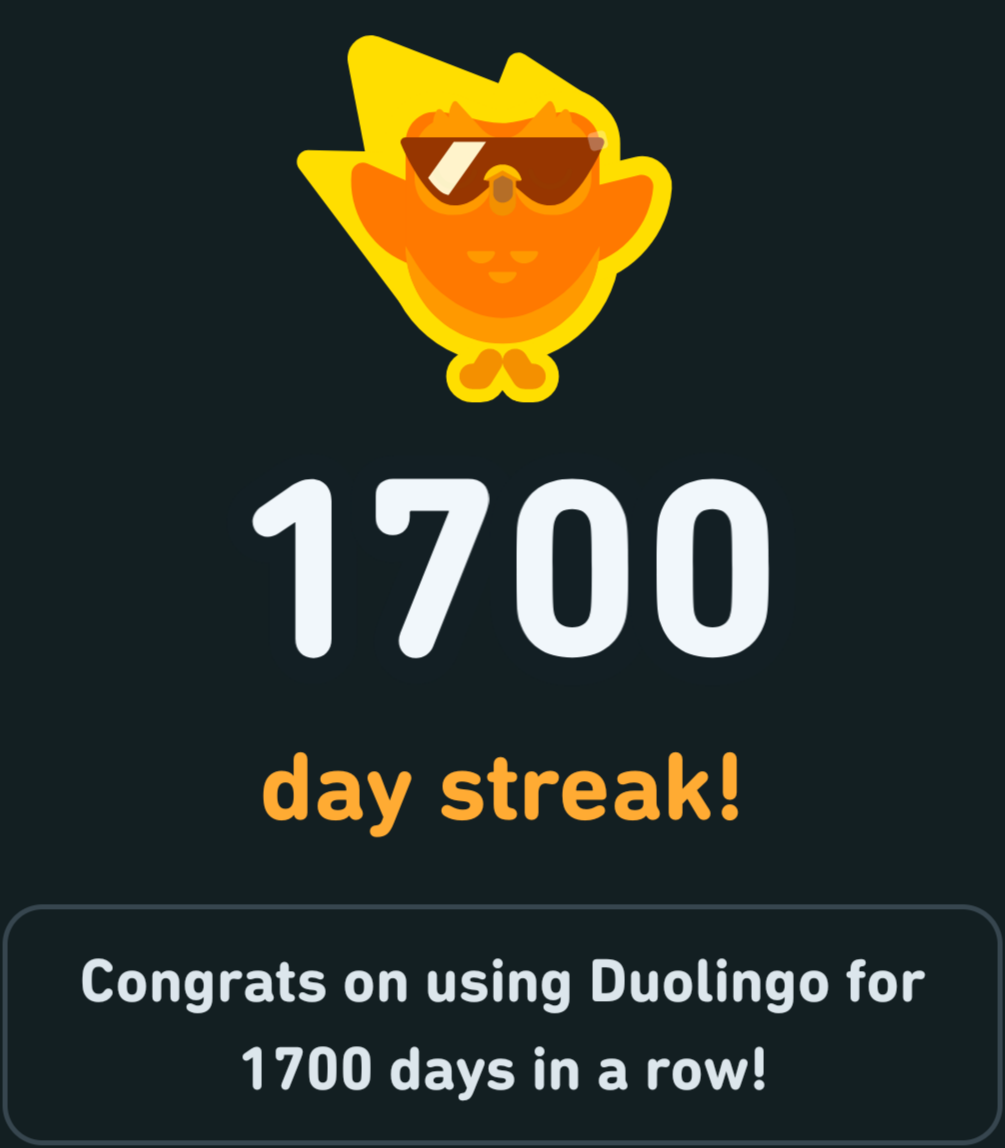 Duolingo's owl mascot wreathed in flames with the caption '1700 day streak! Congrats on using Duolingo for 1700 days in a row!'